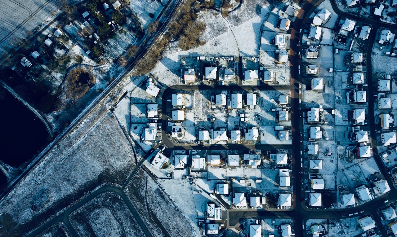 Aerial photograph showcasing a winter landscape of a snowy residential neighborhood.